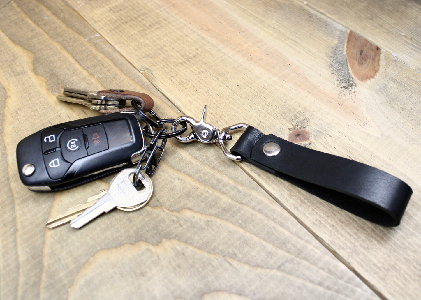 Premium leather keychain with a snap button closure, combining durability and elegance for a sleek, functional accessory.