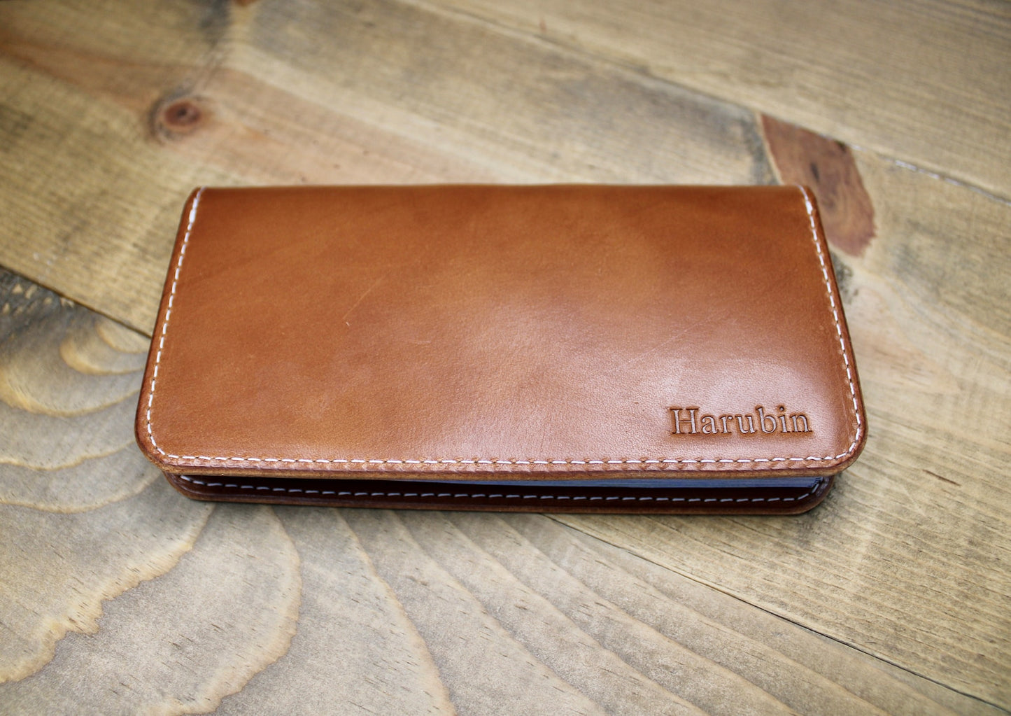 Sophisticated buck brown leather checkbook holder with a smooth finish, durable construction, and convenient storage for checks and cards