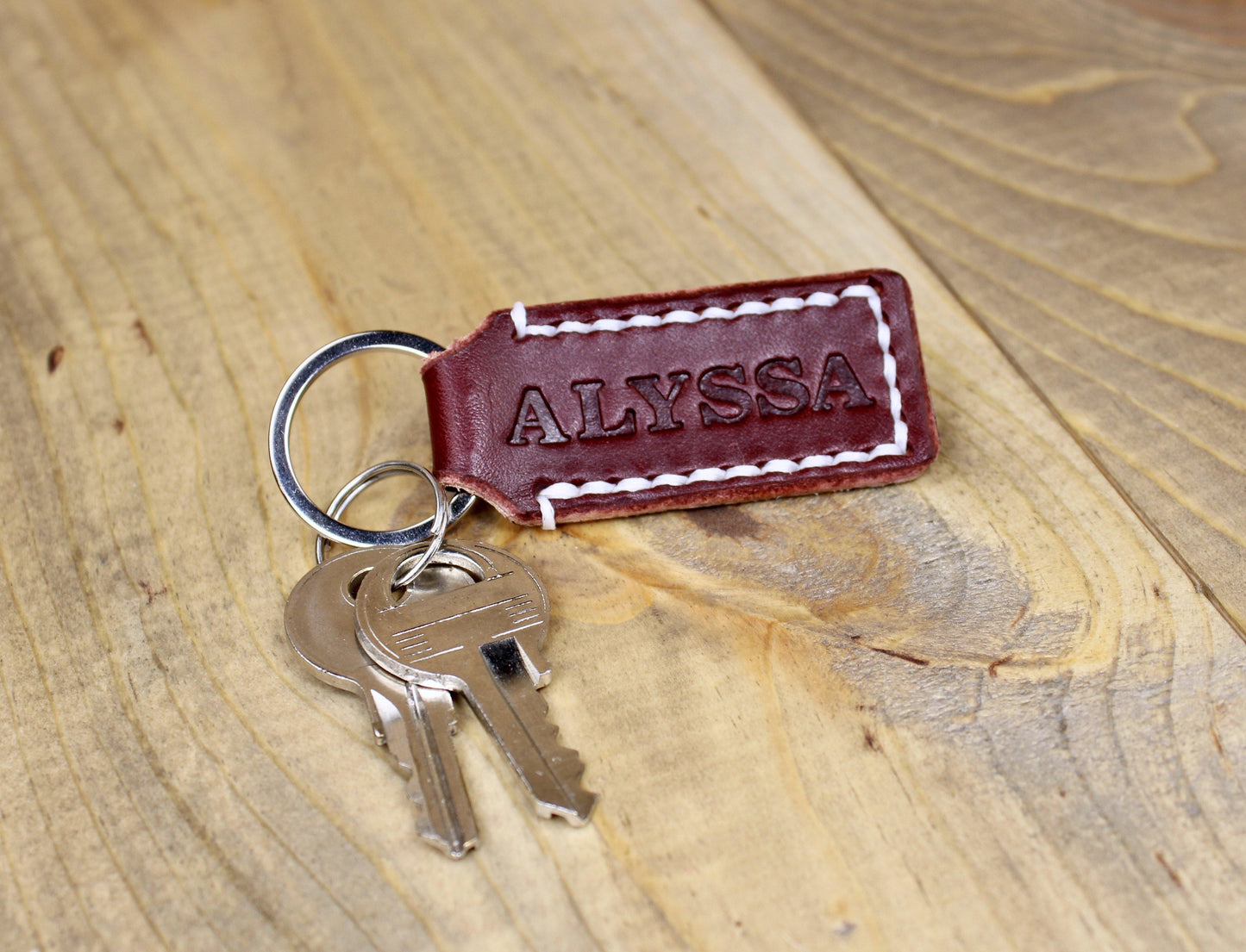 Designs By Harubin Burgundy Leather Keychain with White Thread next to keys for sizing.