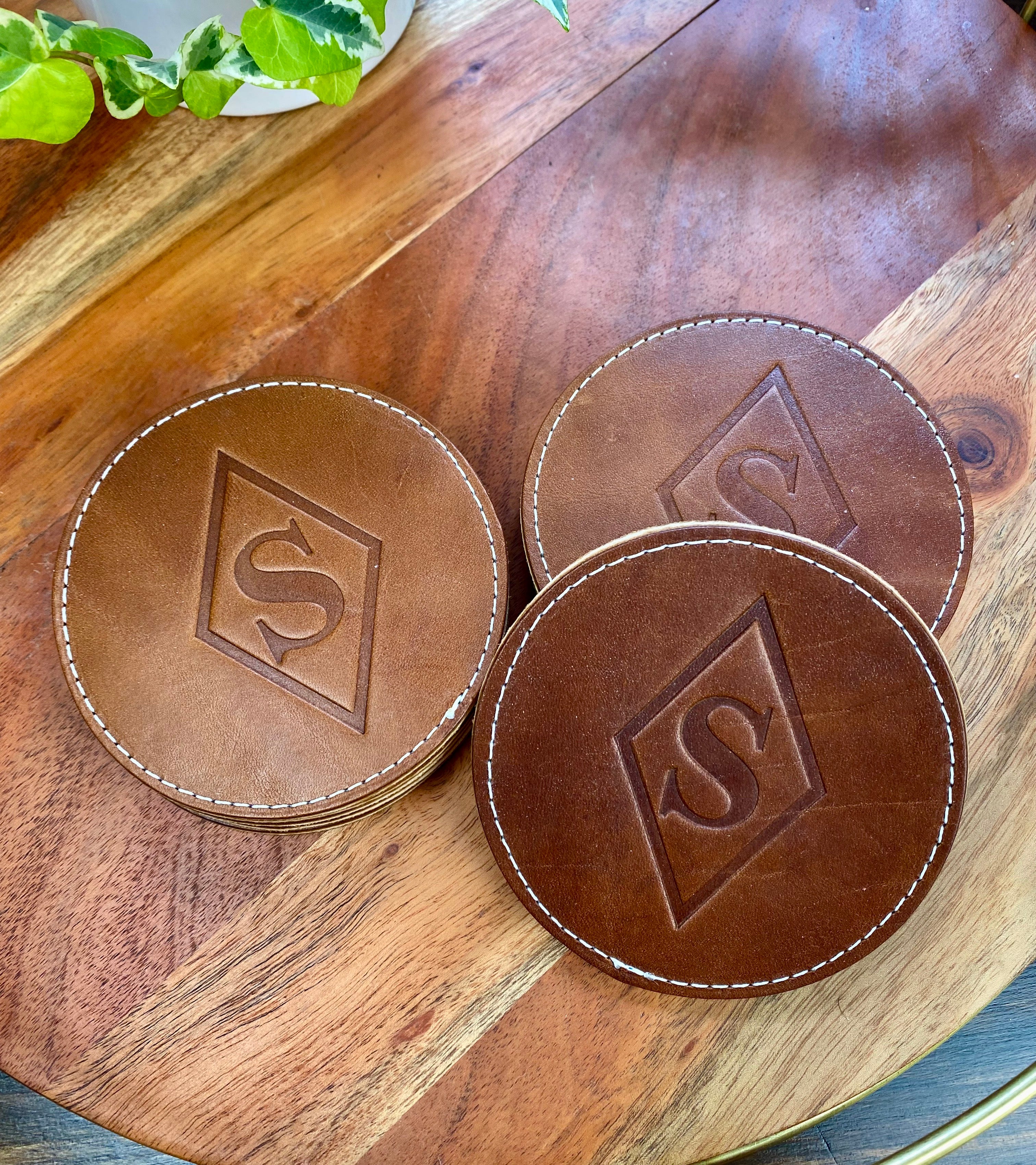 Custom logo leather coasters | buck brown with cream thread | corporate gifts