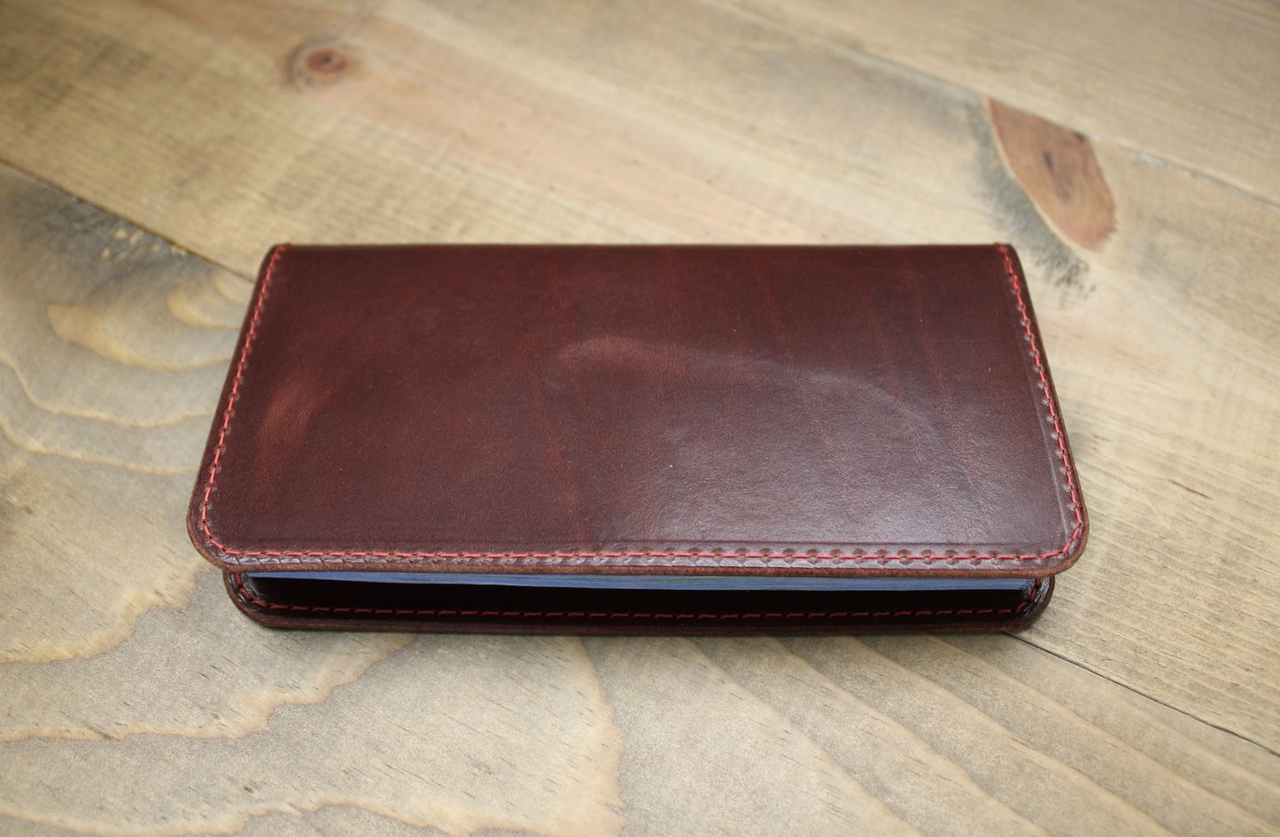 Elegant medium brown leather checkbook holder with a sleek design, durable stitching, and spacious compartments for checks, cards, and essentials."