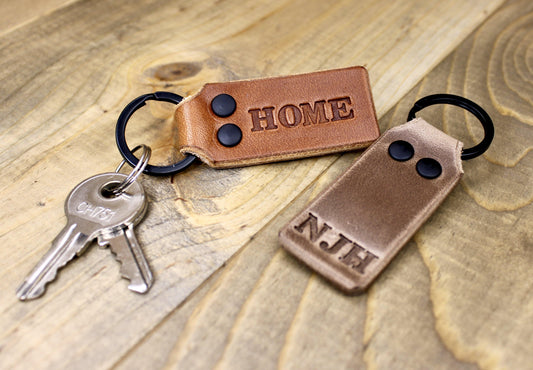Handmade Personalized Leather Keychain. The keychain stamped HOME is Buck Brown Leather and the NJH Stamped Leather is Brown