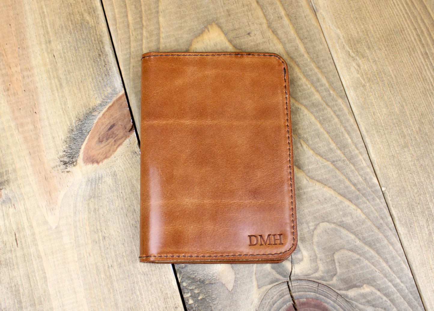 Leather bifold passport holder with embroidered logo